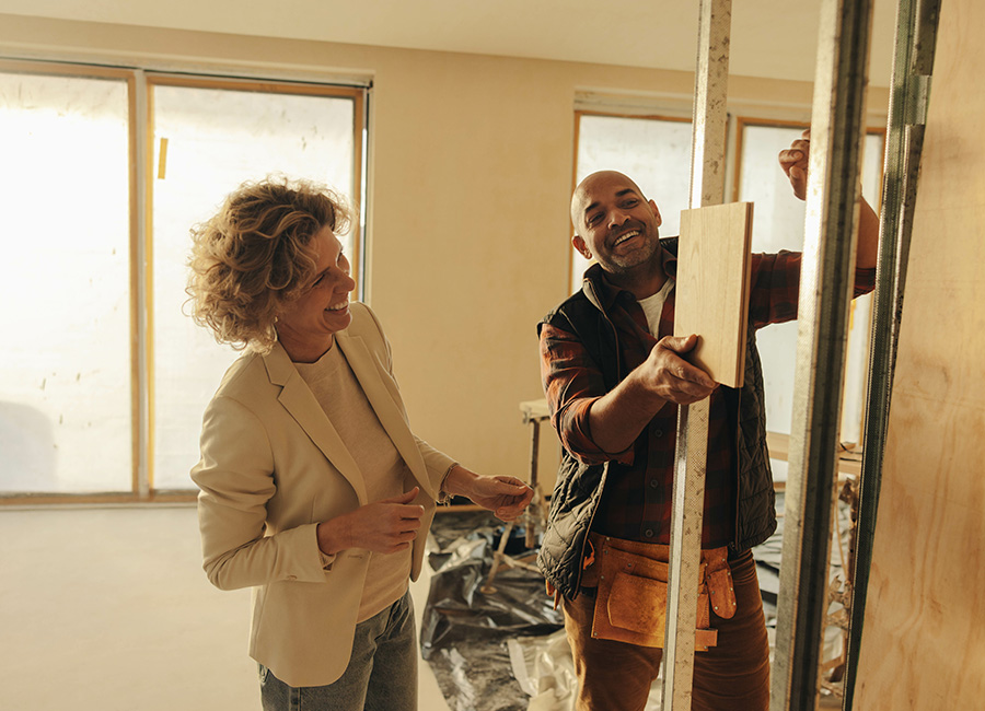 Un maître d'œuvre effectuant une réunion de chantier avec sa cliente pour la construction d'une maison individuelle